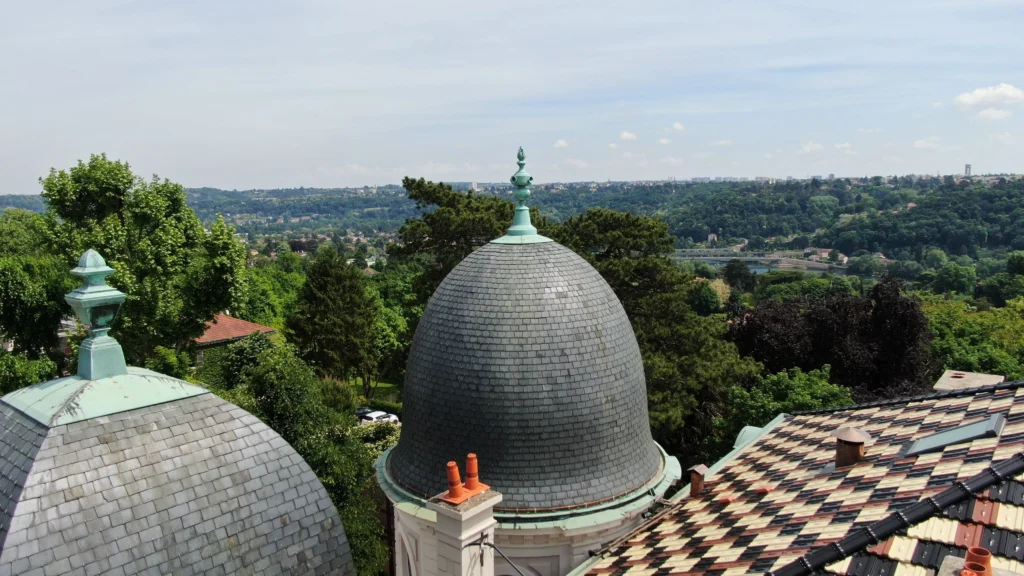 Dôme en ardoises du château avec une vue panoramique sur la vallée environnante.