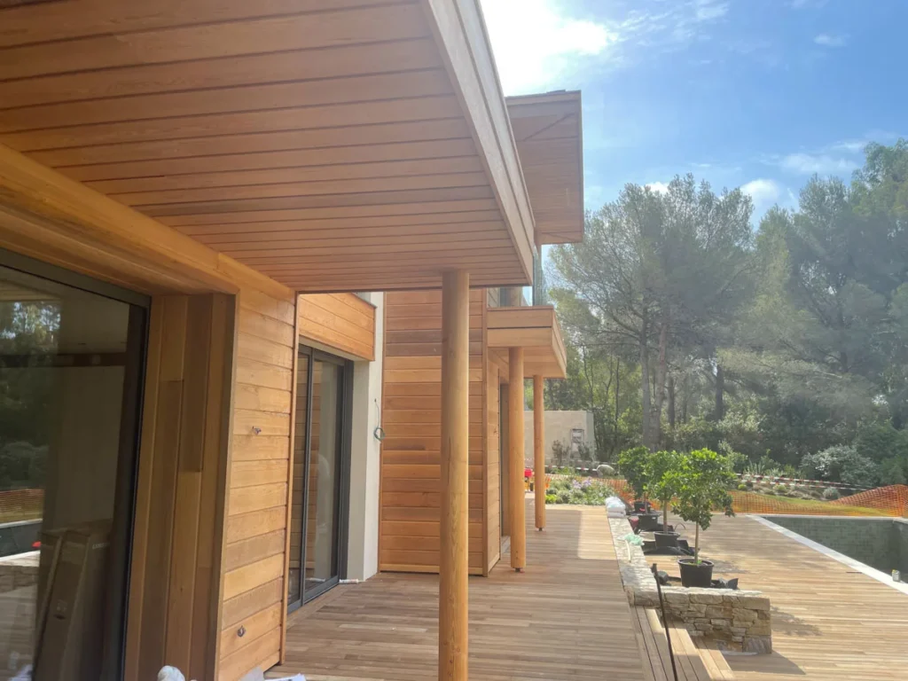 Façade et terrasse en bois avec vue sur la nature environnante.