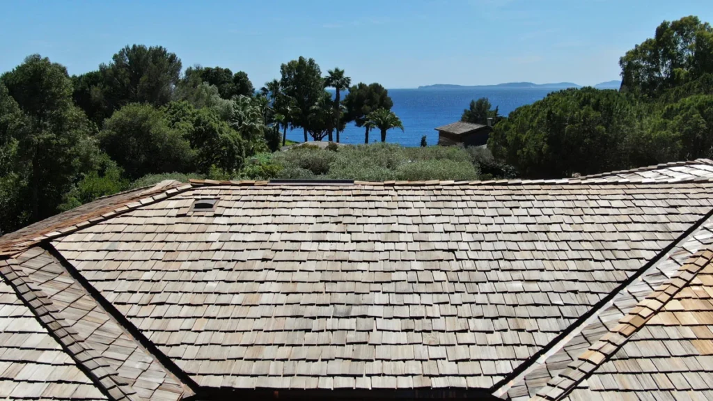 Toiture en bois avec vue sur la mer et un paysage méditerranéen.